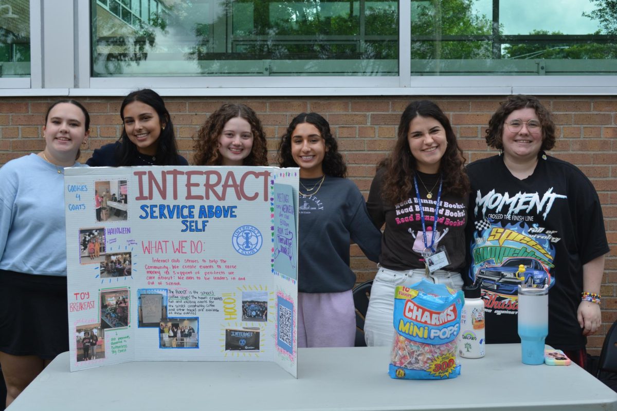 Interact Club members Natalie Keveney, Sama Sahib,  Grace Pinho, and Haneen Awada along with adviser Maria  Manolias and Roost Adviser Alfie Ormsbee promote the club at the Raven Rally. 