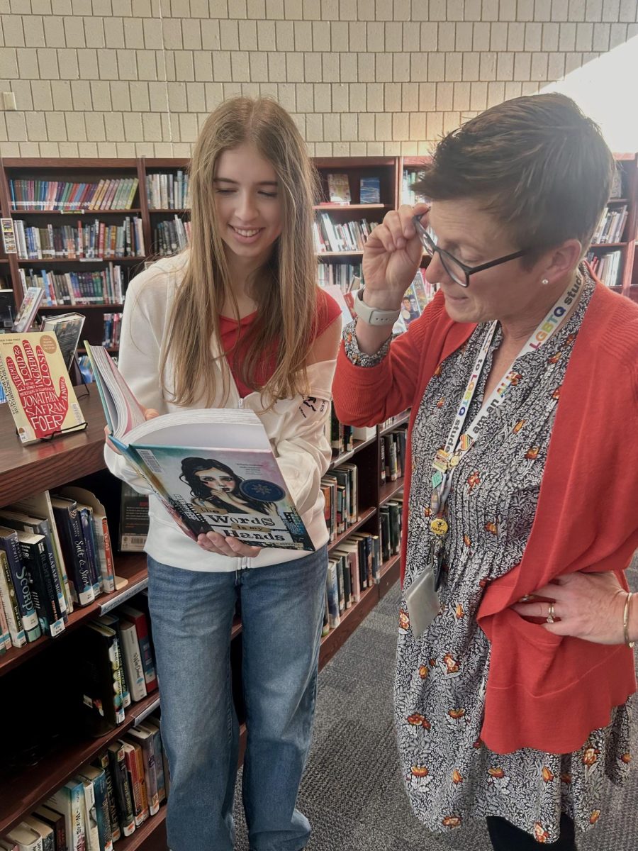 Mrs. Hermon helps junior Eva Elliott choose a book. 
